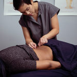 This is an image of Dr. Khanita placing acupuncture needles on a client’s back.